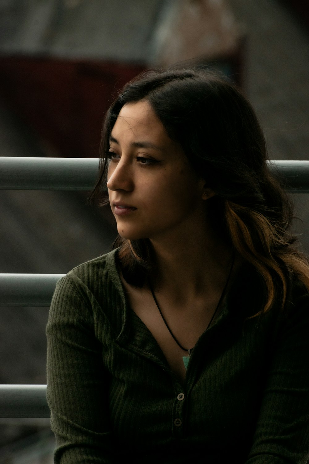 a woman sitting on a bench with a cell phone in her hand