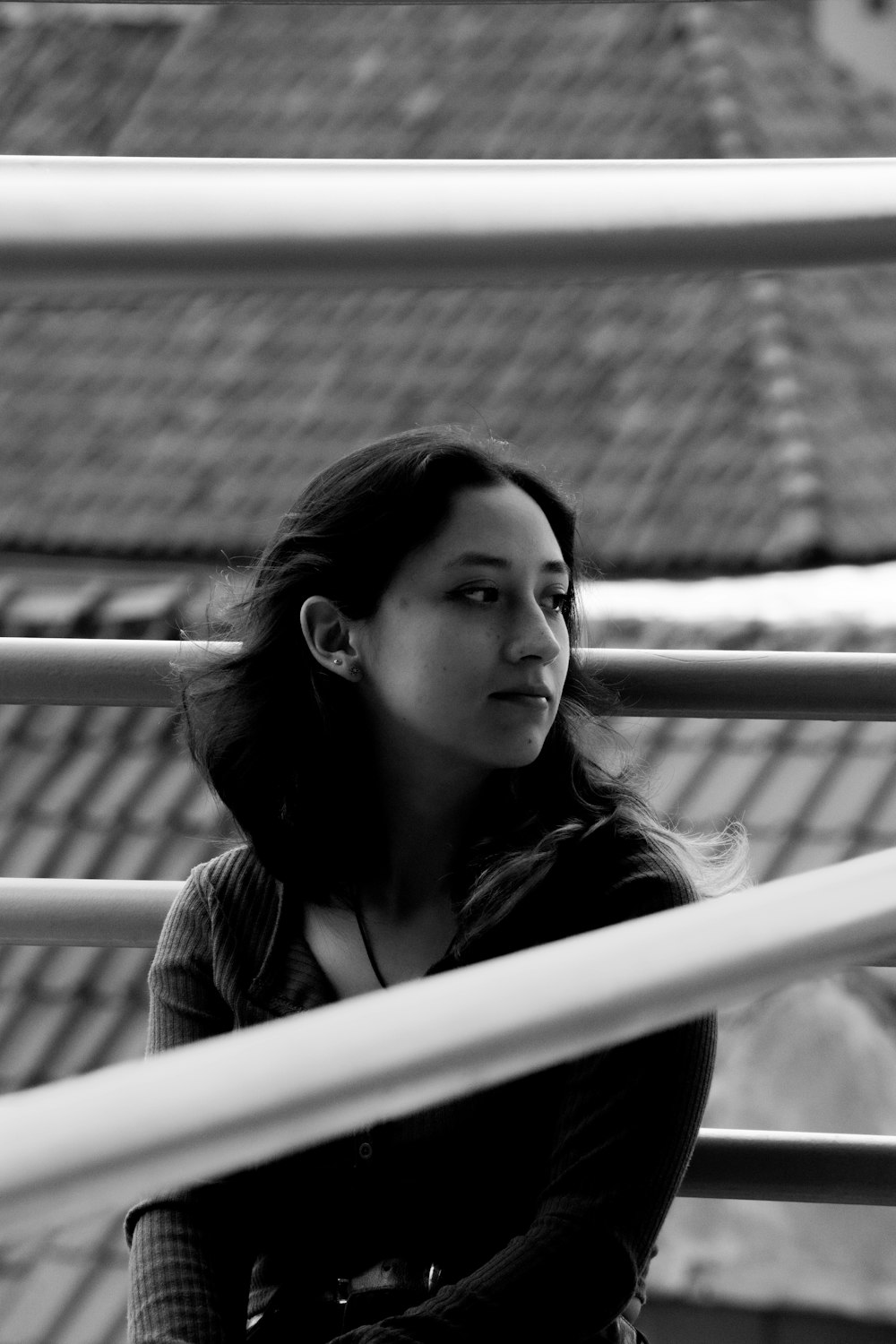 a woman sitting on a balcony with a cell phone in her hand