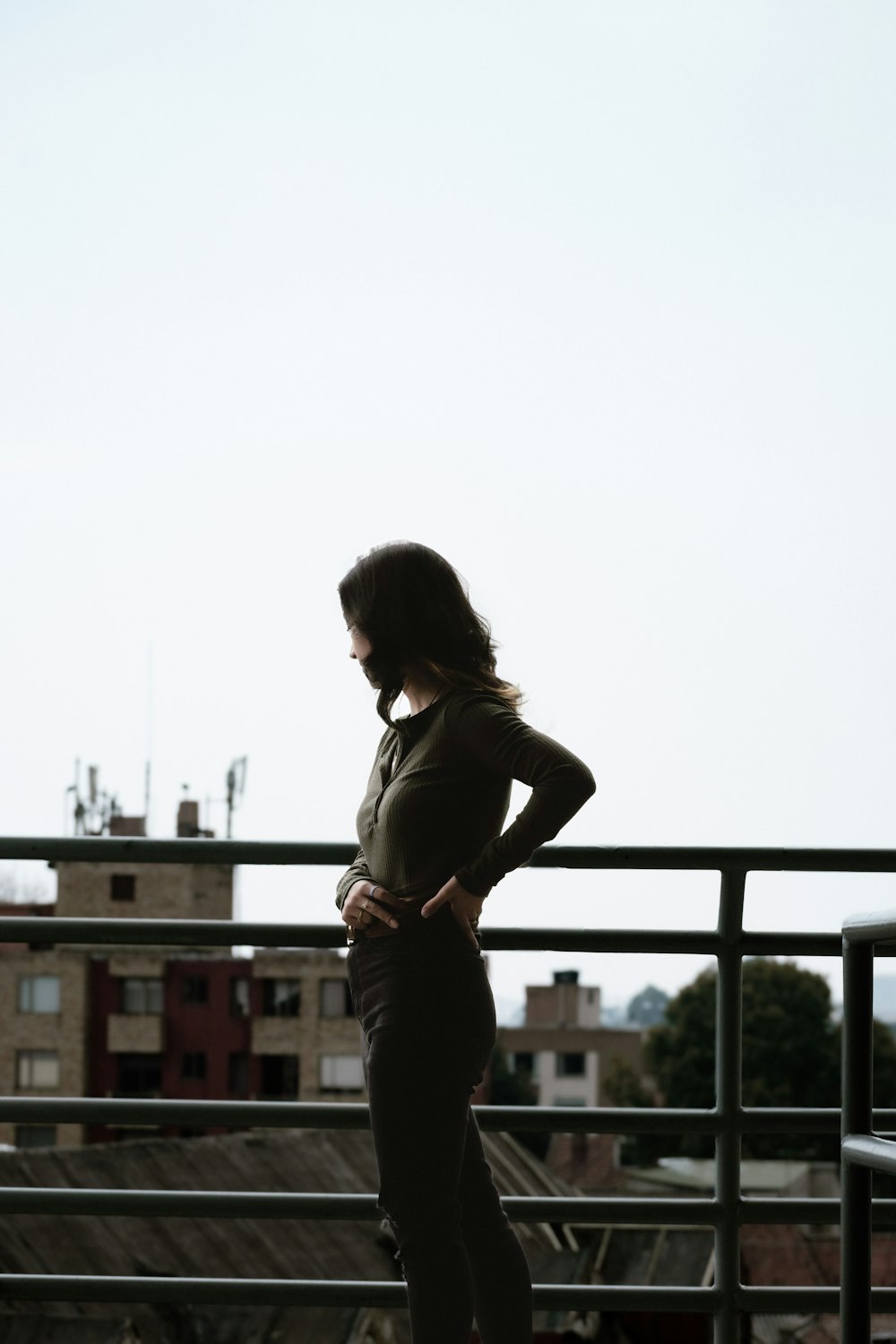 a woman standing on a balcony with her hands on her hips