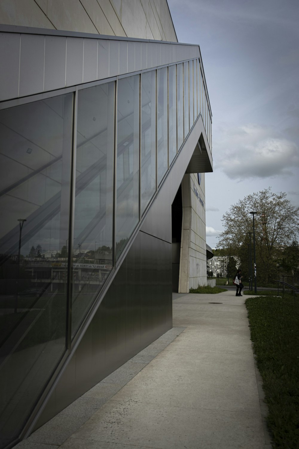 a person walking down a sidewalk next to a building