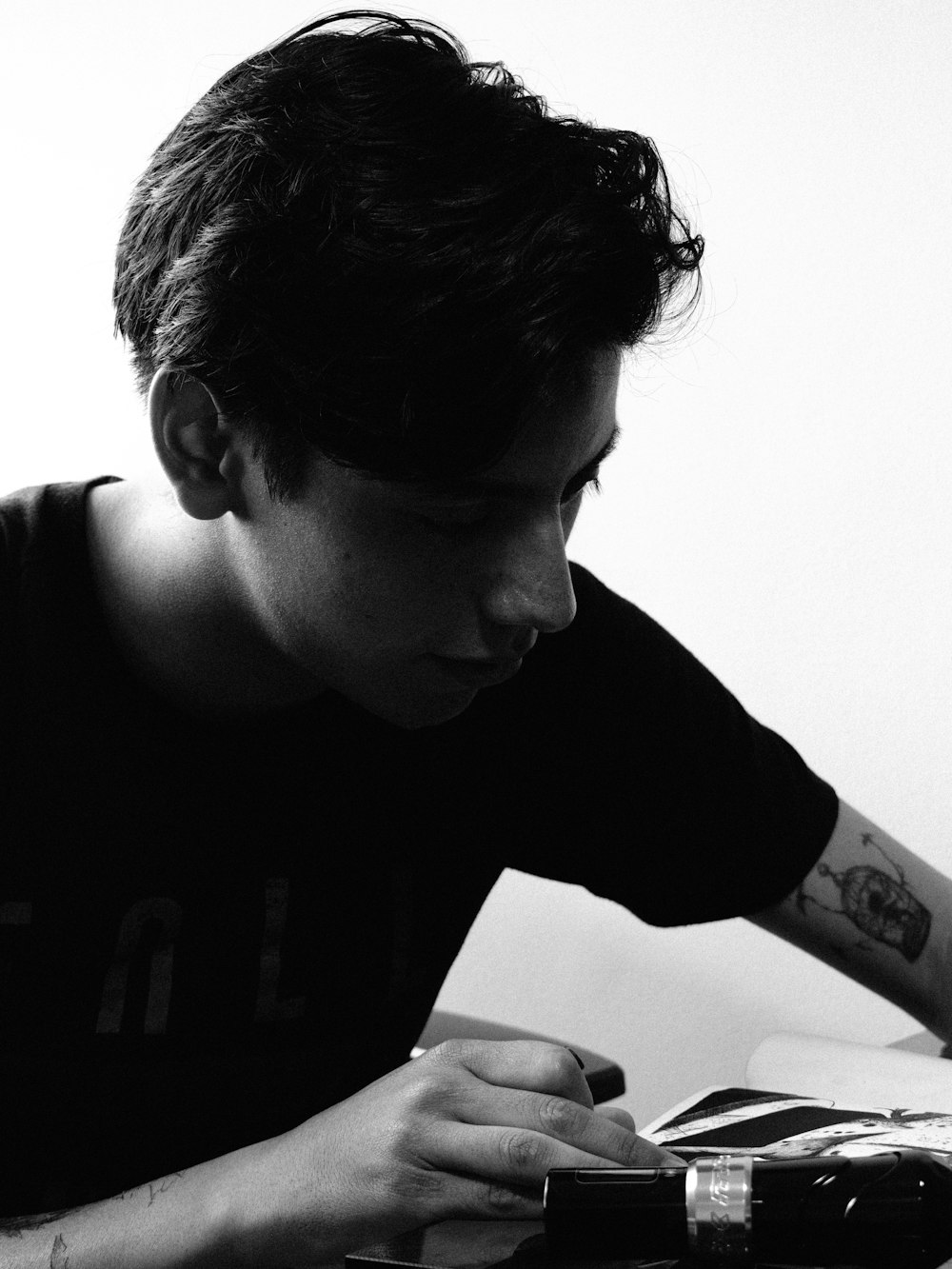 a young man sitting at a desk writing on a piece of paper