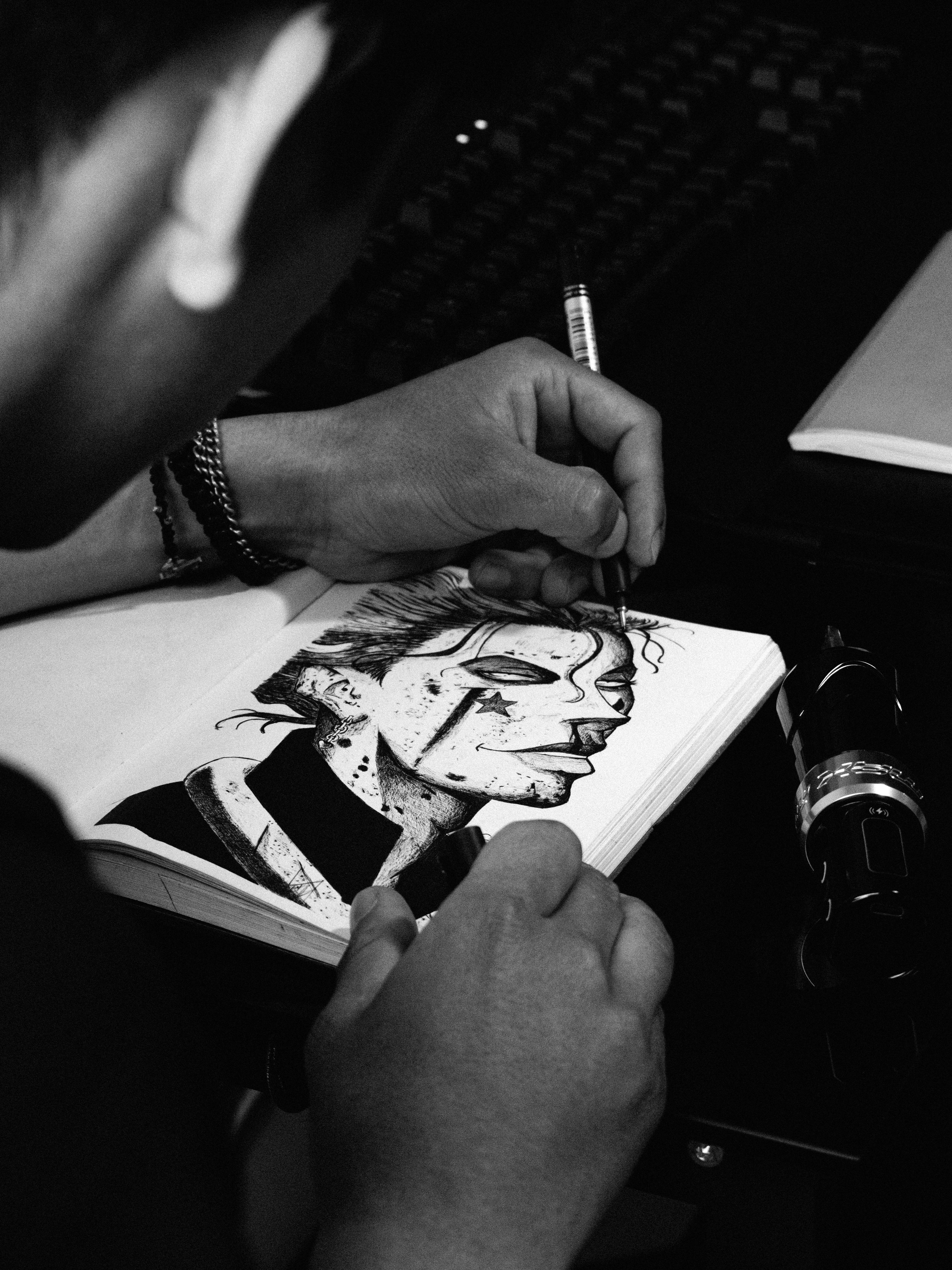 Close-up tangan artist sedang sketching karakter dengan pensil di sketchbook