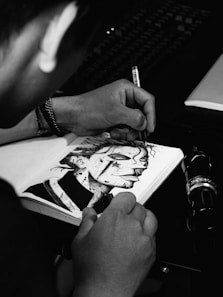 a man is drawing a picture on a notebook