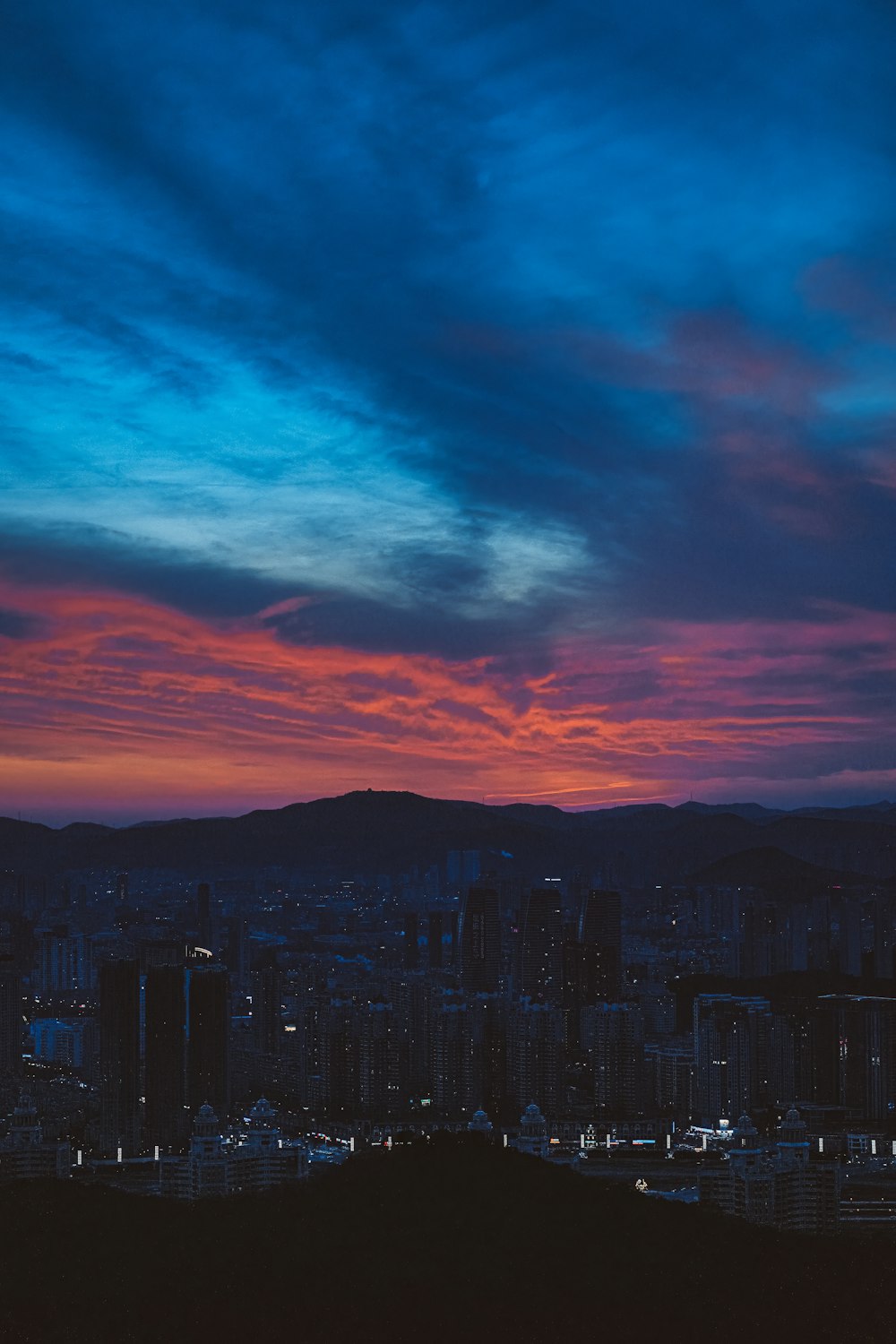 a view of a city at sunset from a hill