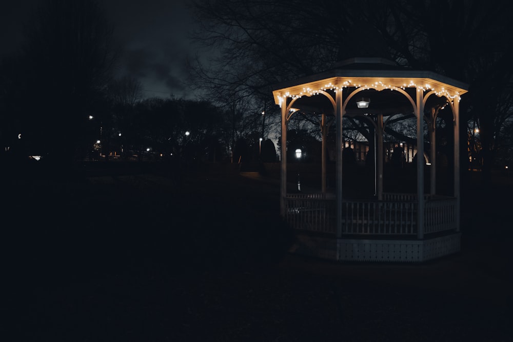 a lit up gazebo in a park at night