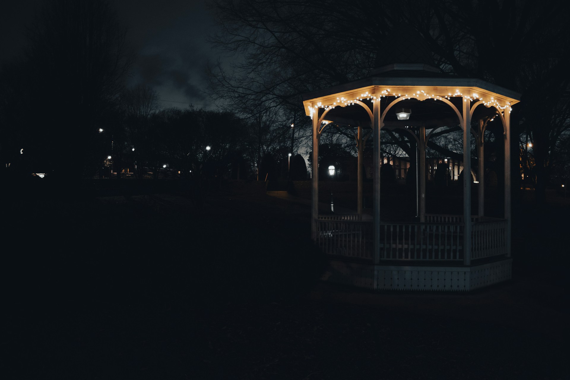 a lit up gazebo in a park at night