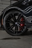 a close up of a black car with red spokes