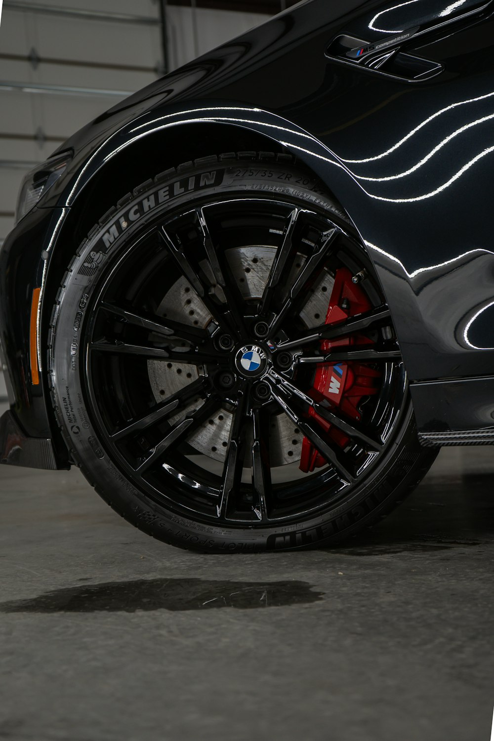 a close up of a black car with red spokes