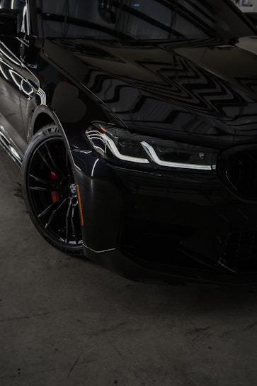 a black car parked inside of a garage