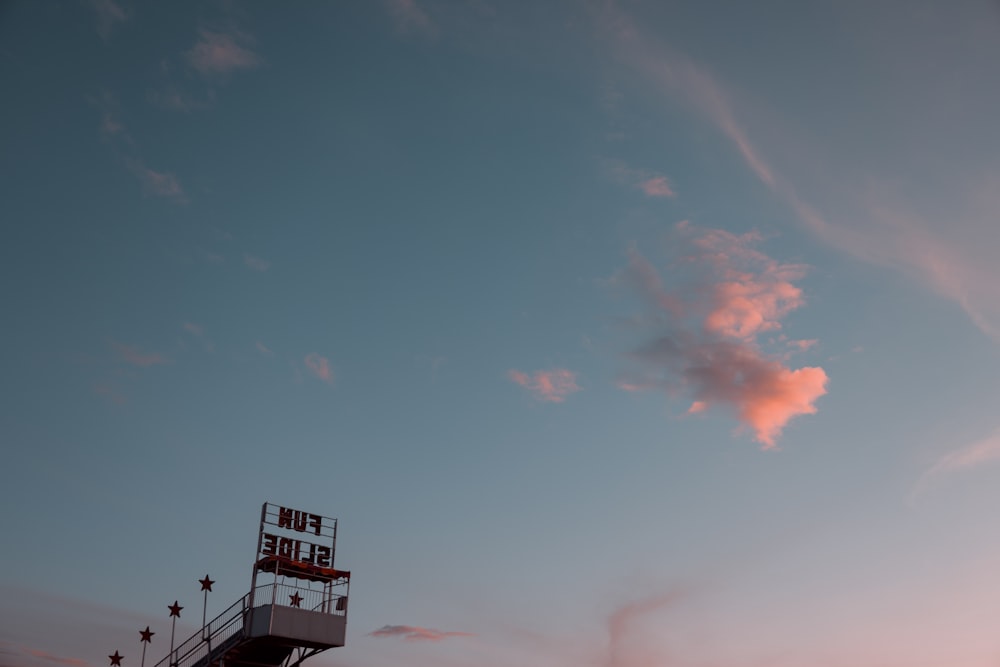 Un nuage rose est dans le ciel au-dessus d’un bâtiment