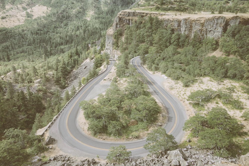 an aerial view of a winding road in the mountains