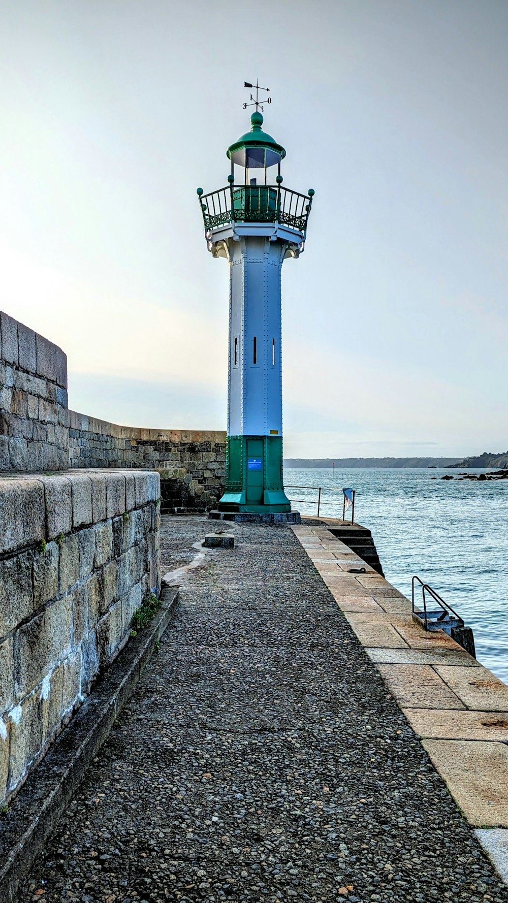 a blue and white light house next to a body of water