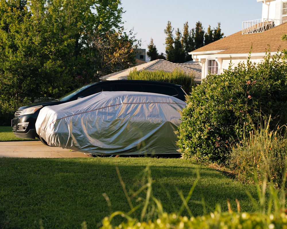 a car covered in a tarp parked on the side of the road