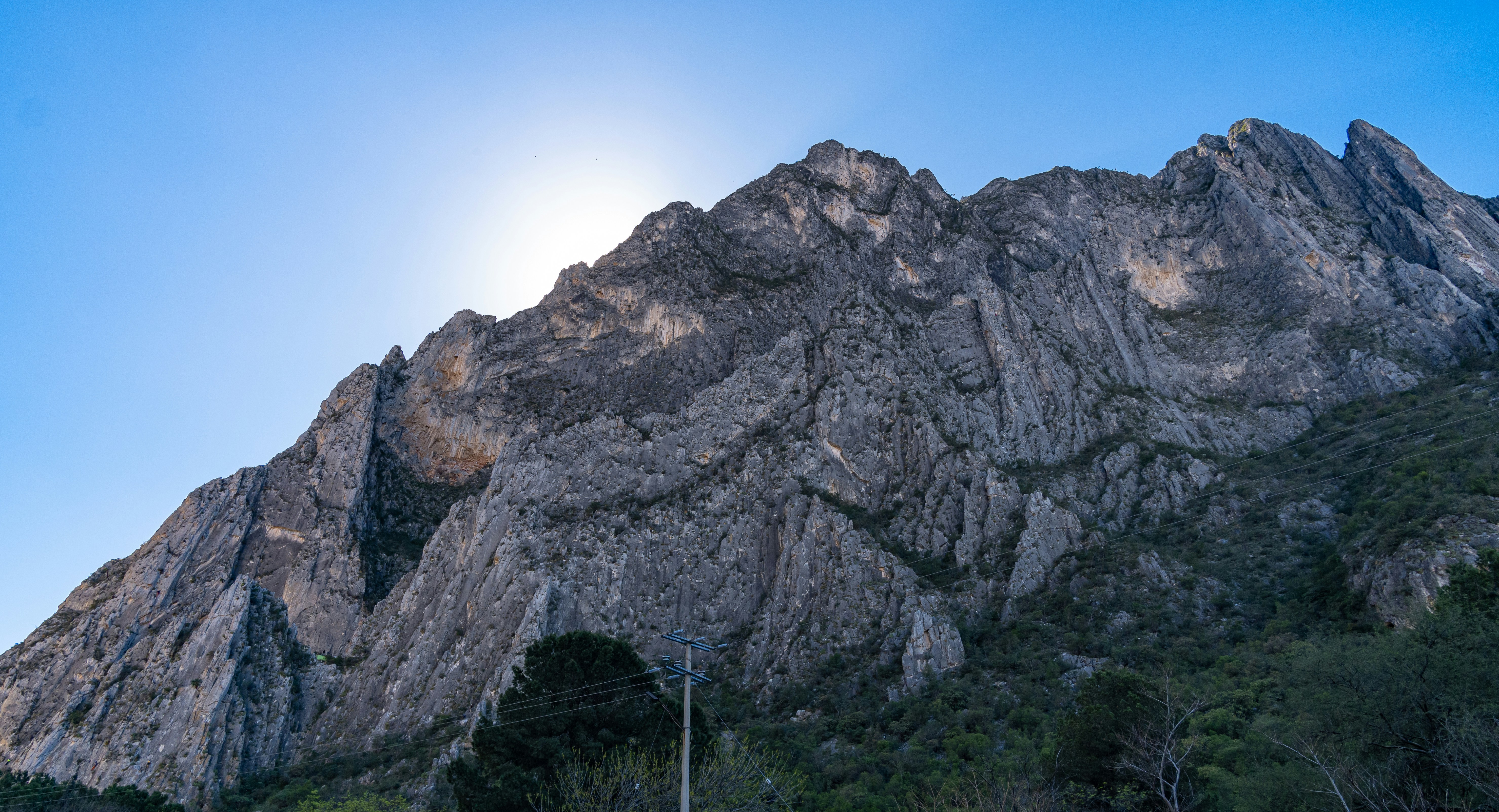 the sun is shining on a mountain side