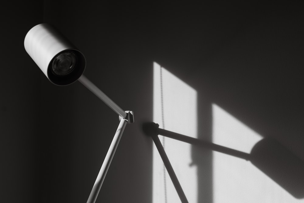 a black and white photo of a lamp on a wall