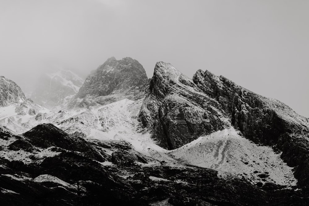 a black and white photo of snow covered mountains