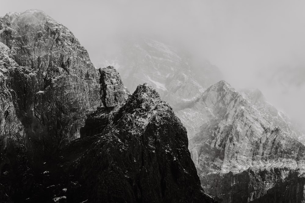 a black and white photo of mountains covered in snow