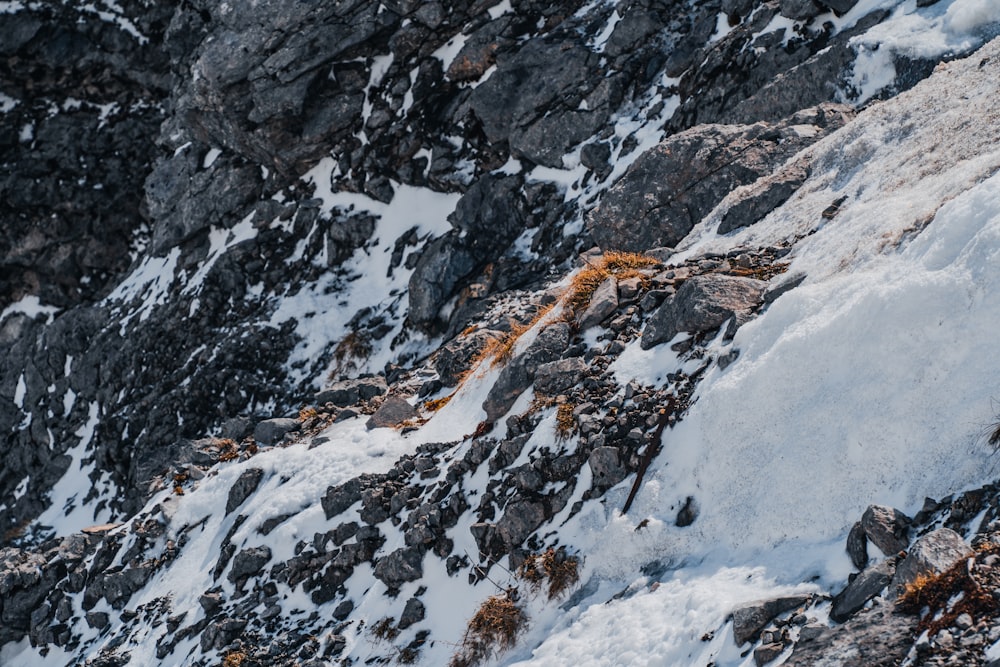 a man climbing up the side of a snow covered mountain