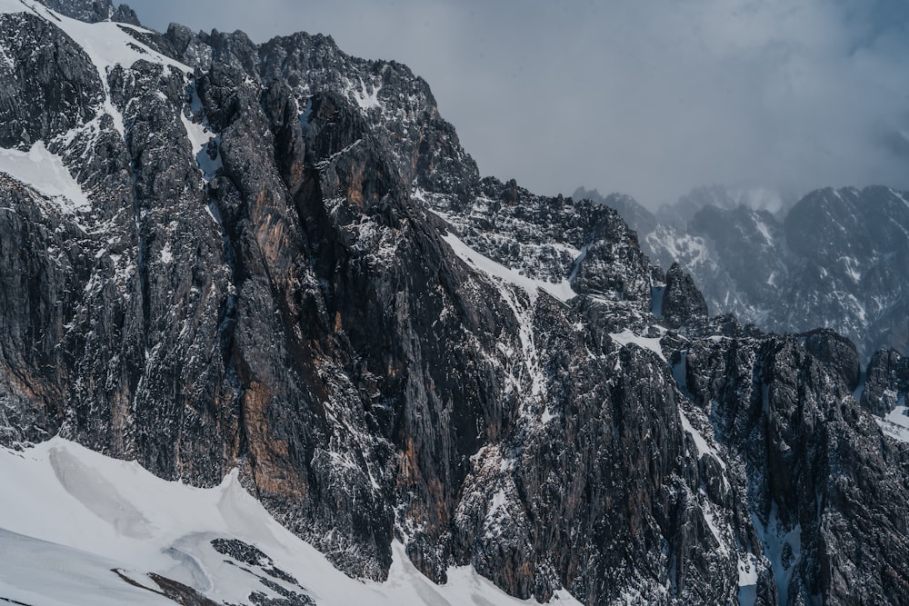 a mountain covered in snow and surrounded by clouds