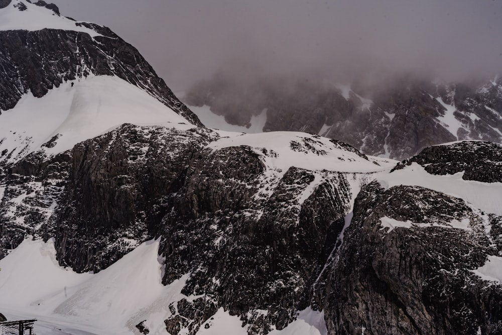 a mountain covered in snow and clouds