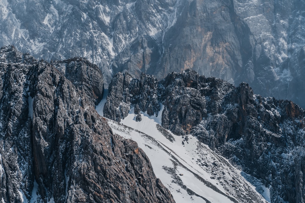 a snow covered mountain with a trail going through it