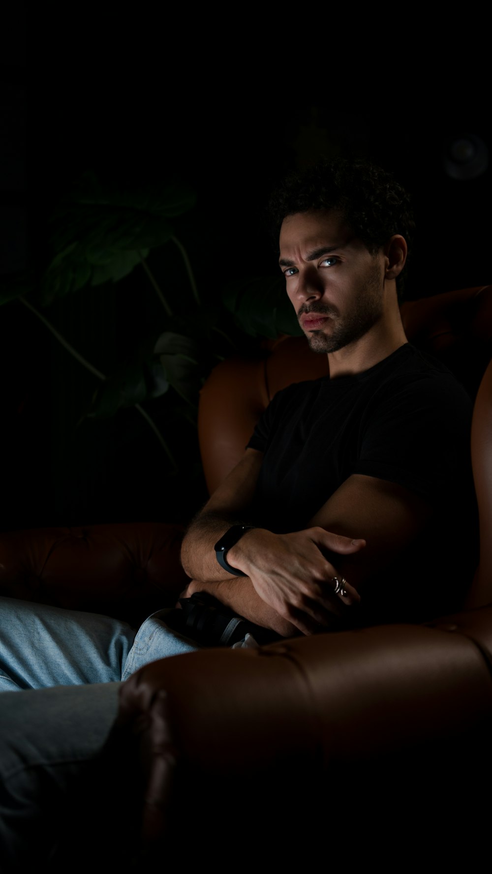 a man sitting in a chair in the dark