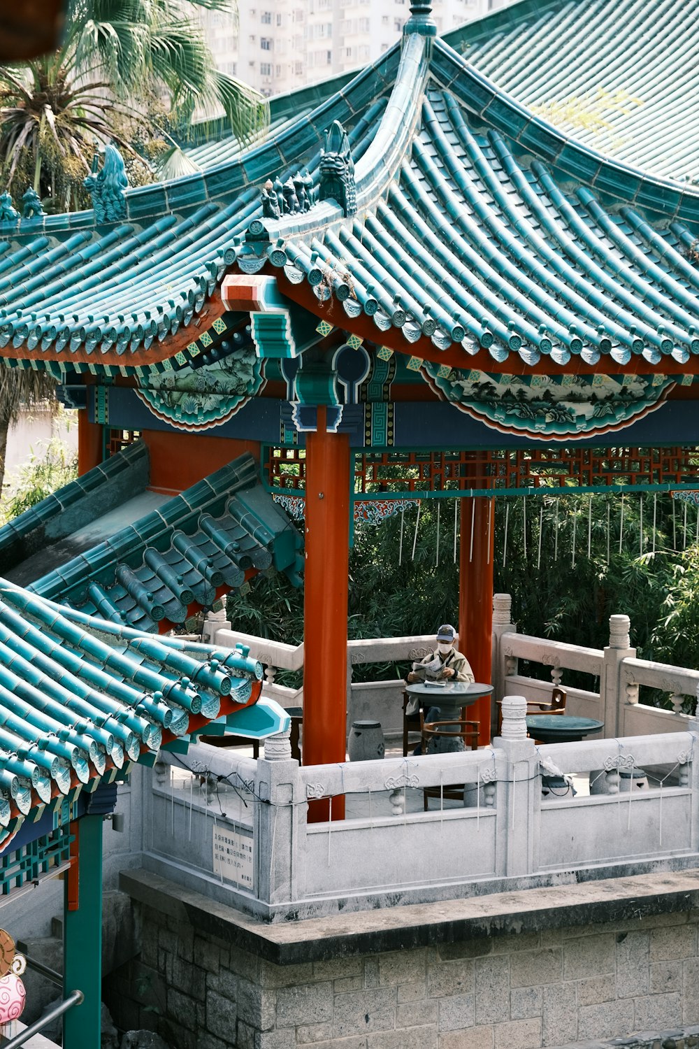 un bâtiment bleu et rouge avec une personne assise sur un banc