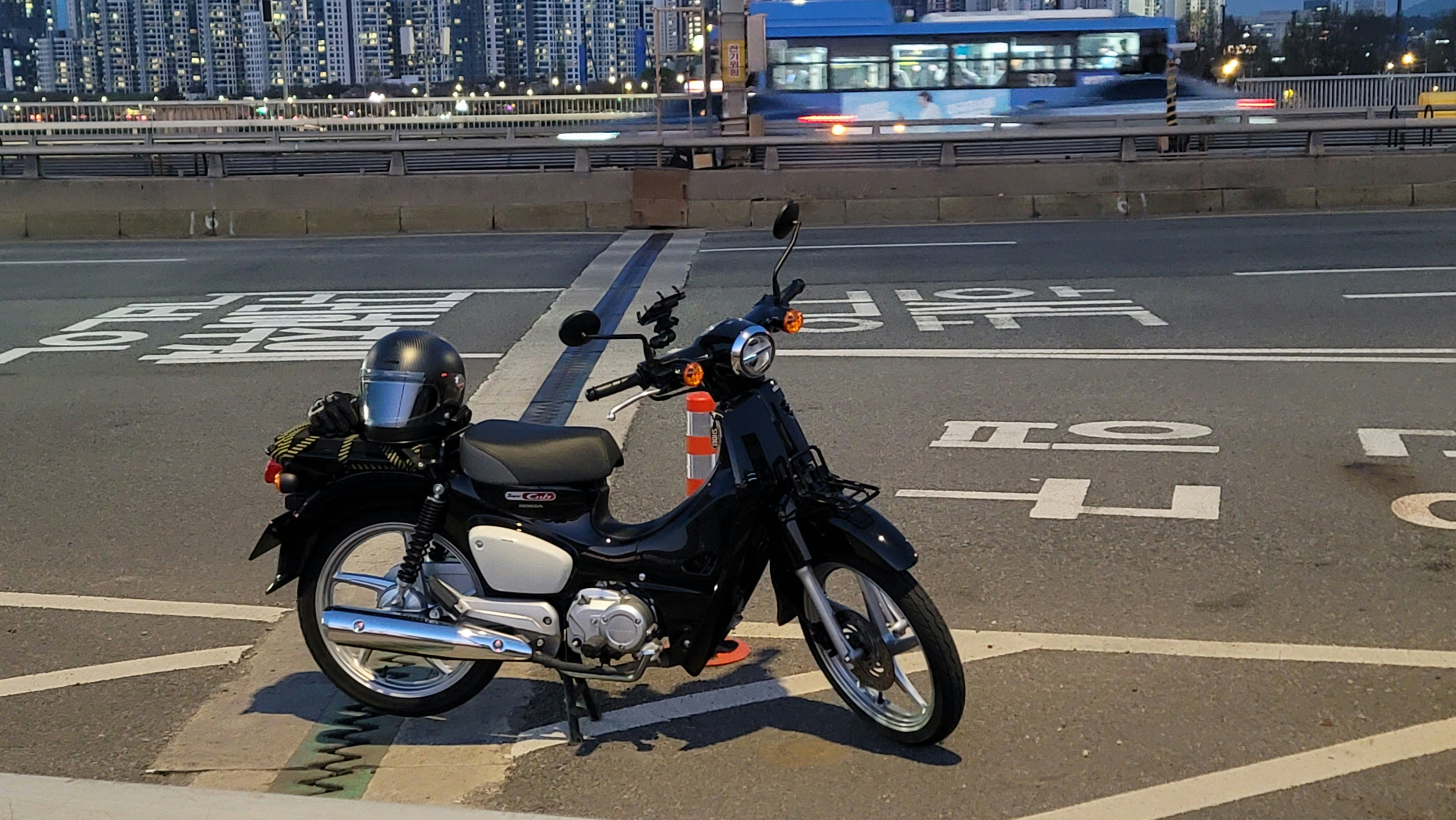 Motorcycle parked on a dark urban street, moody night lighting, deep shadows on asphalt
