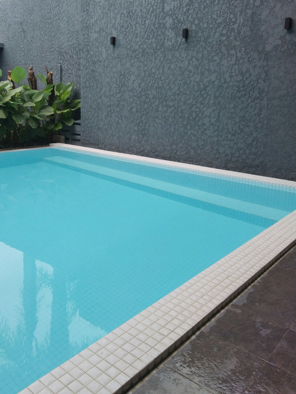 a large swimming pool with a tiled floor