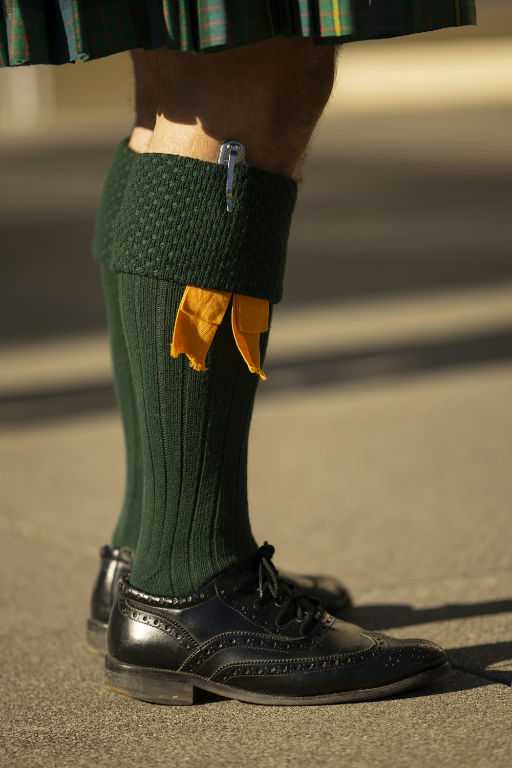 a man in a kilt and a pair of shoes