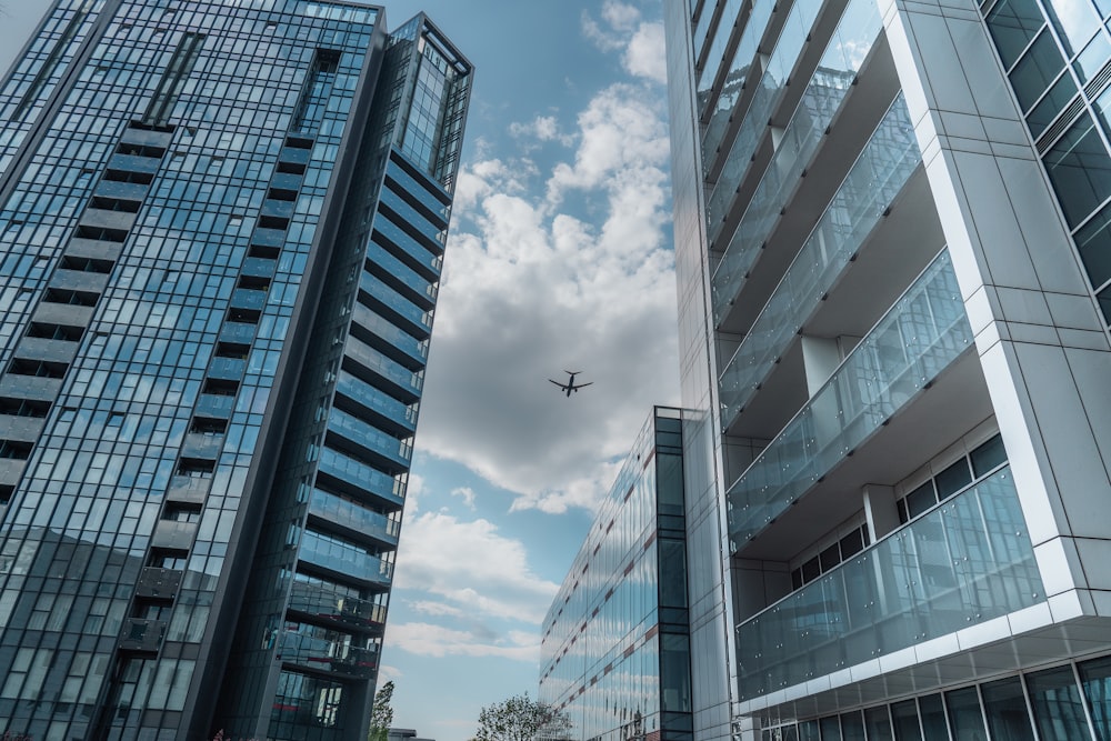 an airplane flying over a city with tall buildings