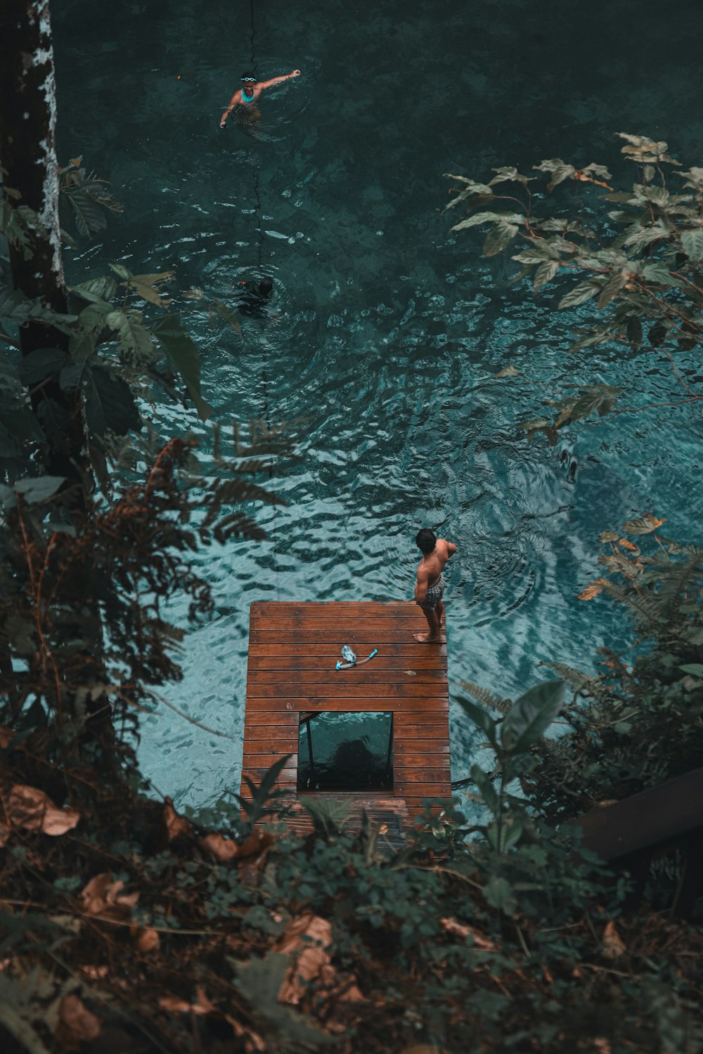 a person standing on a dock in a body of water