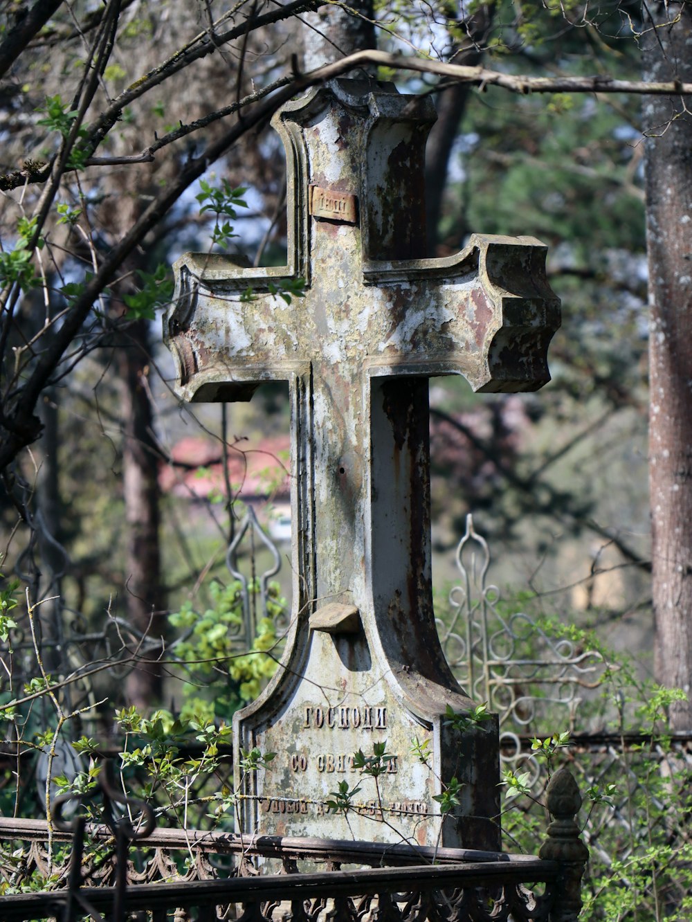 an old, rusted cross sits in the middle of a cemetery