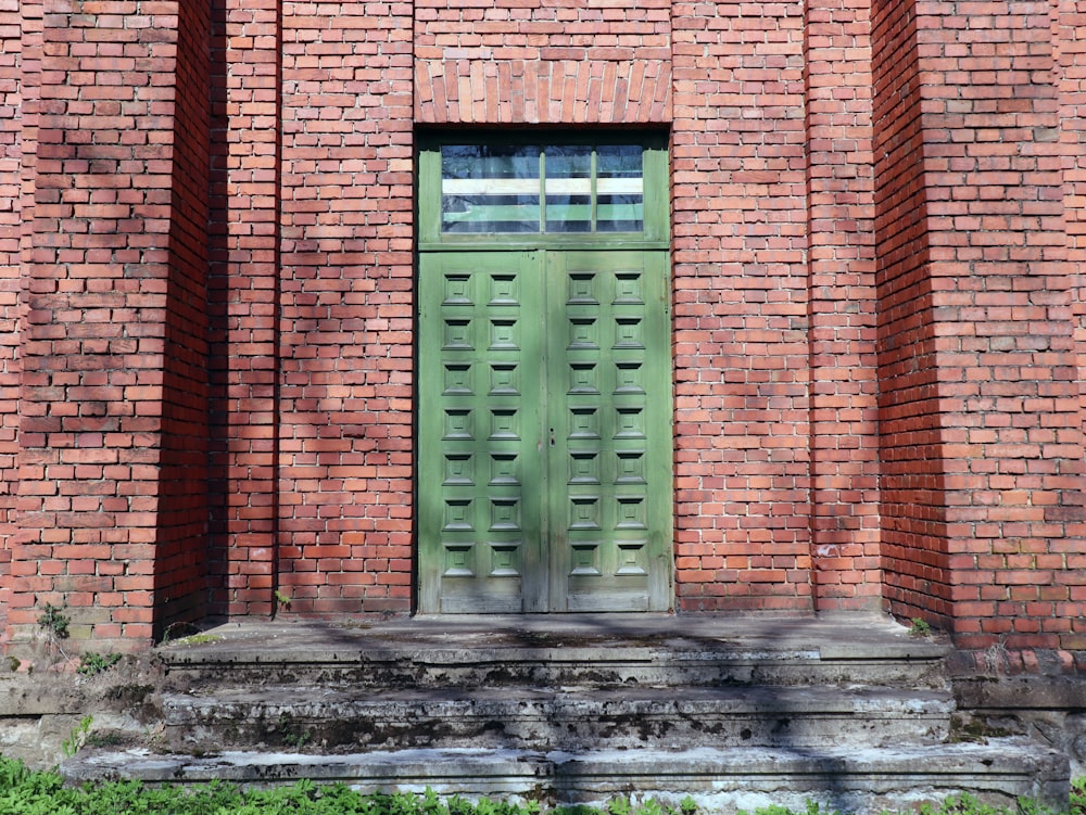 a green door on a red brick building