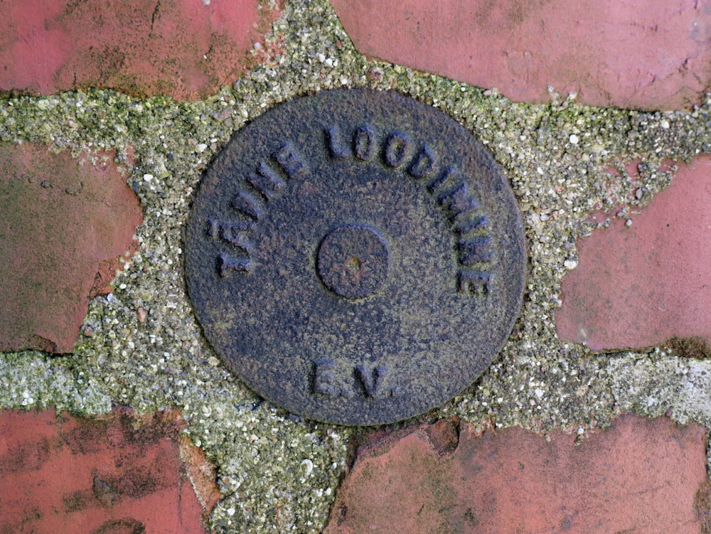 a manhole cover on a brick sidewalk