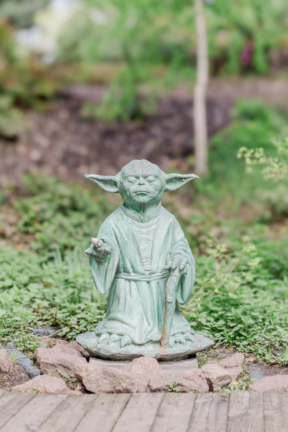 a statue of a yoda holding a potted plant