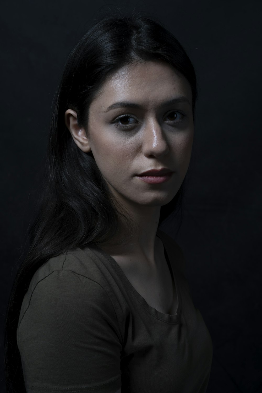 a woman is posing for a picture in a dark room