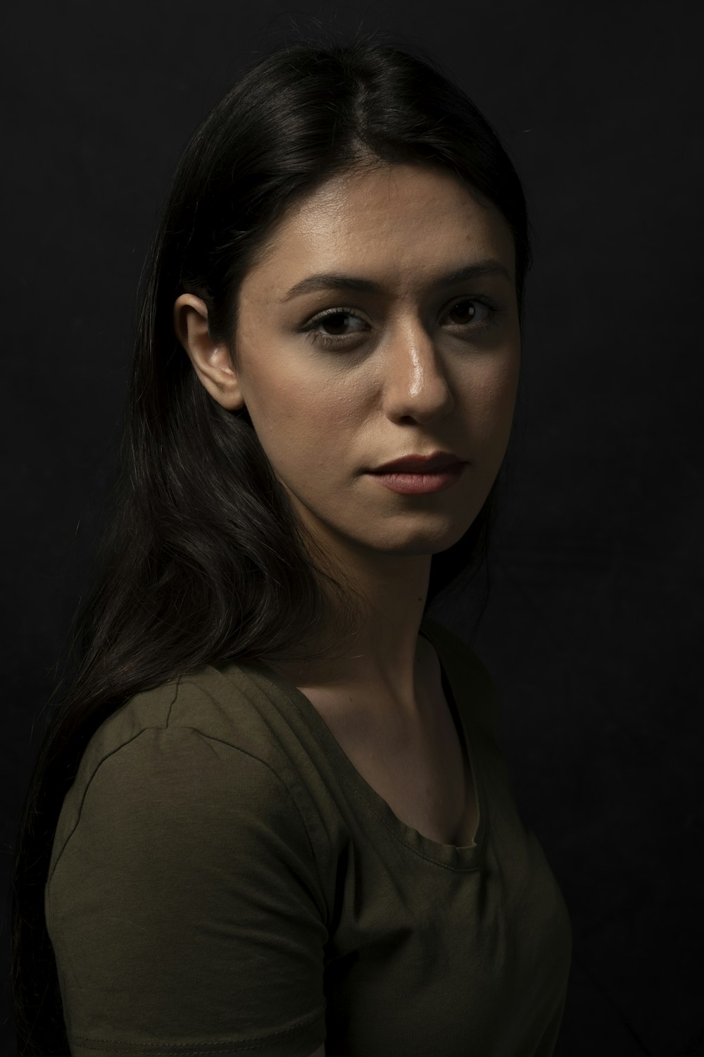 a woman in a green shirt posing for a picture