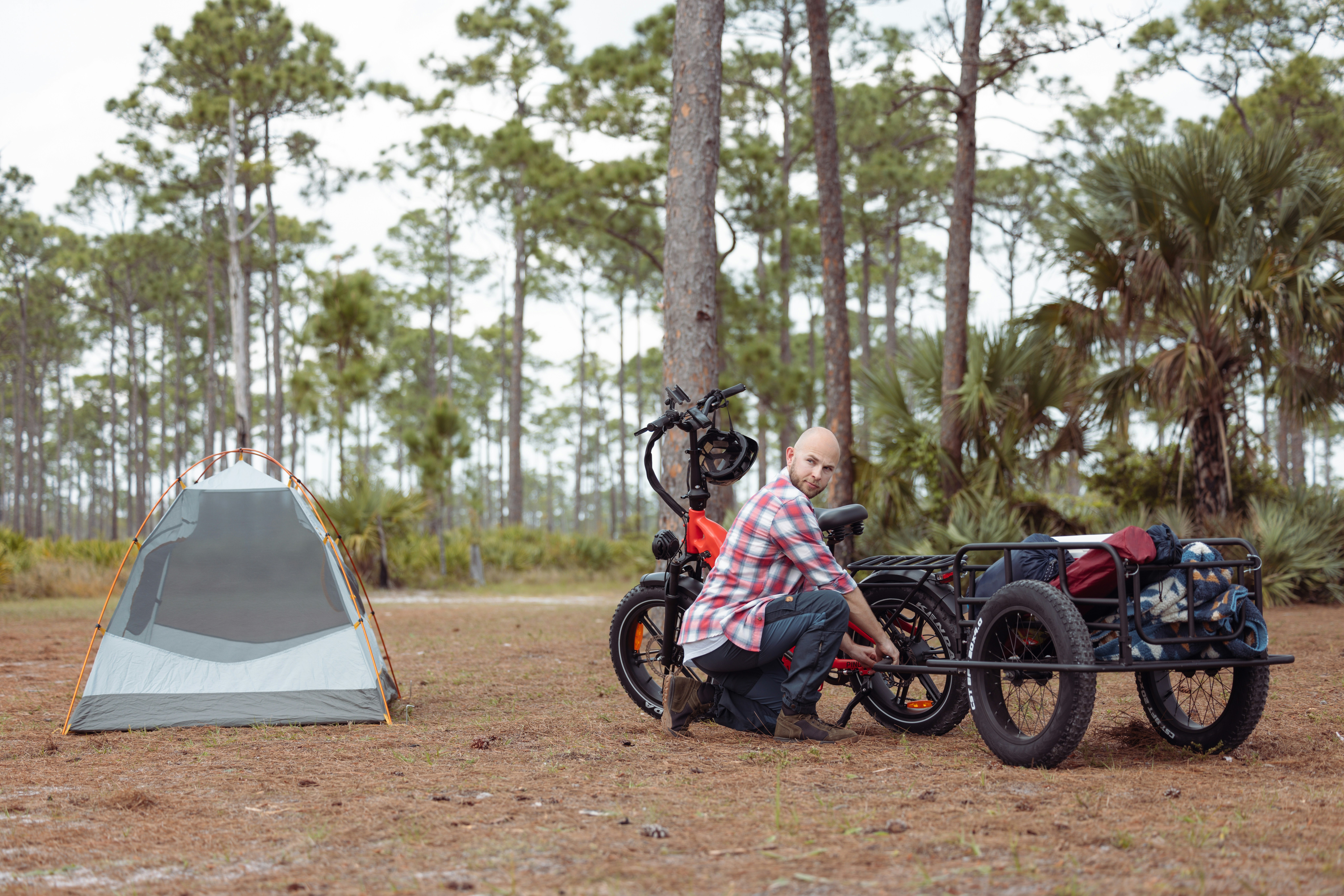 a man sitting on a motorcycle next to a tent