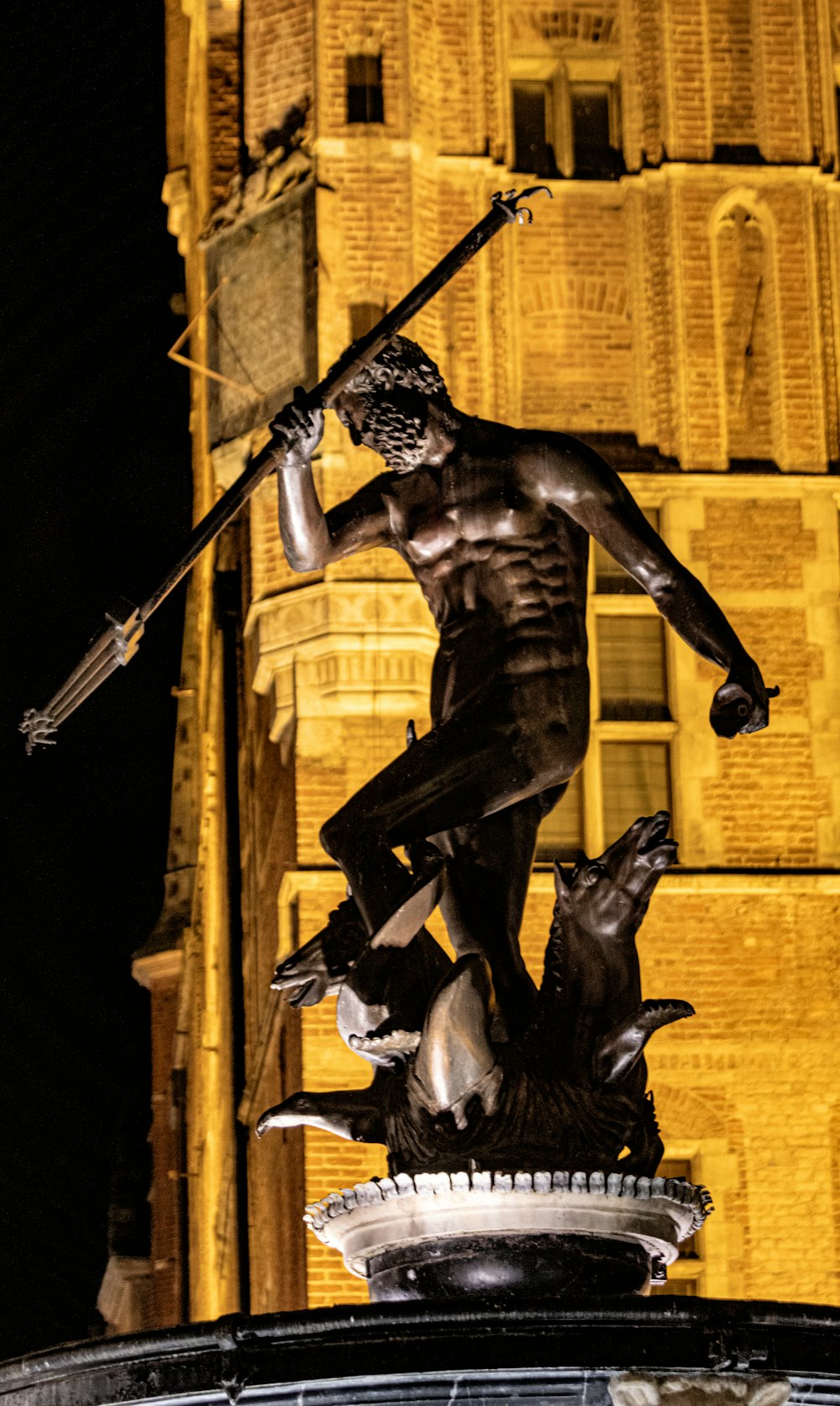 a statue of a man holding a sword on top of a fountain