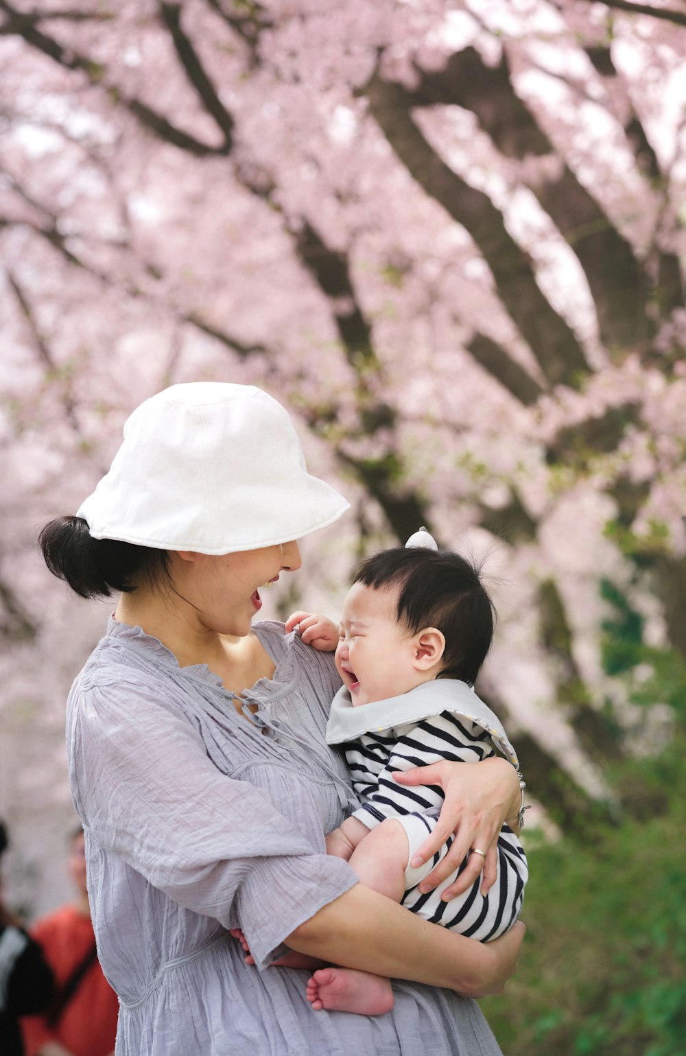 赤ん坊を腕に抱いた女性