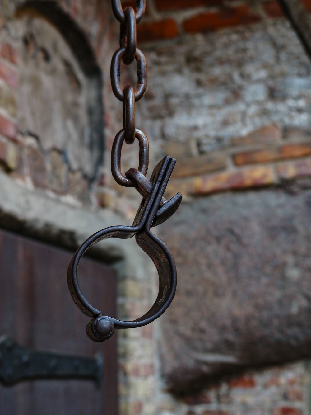 a close up of a metal object hanging from a chain