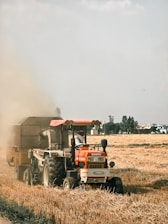 a tractor is driving through a field of wheat