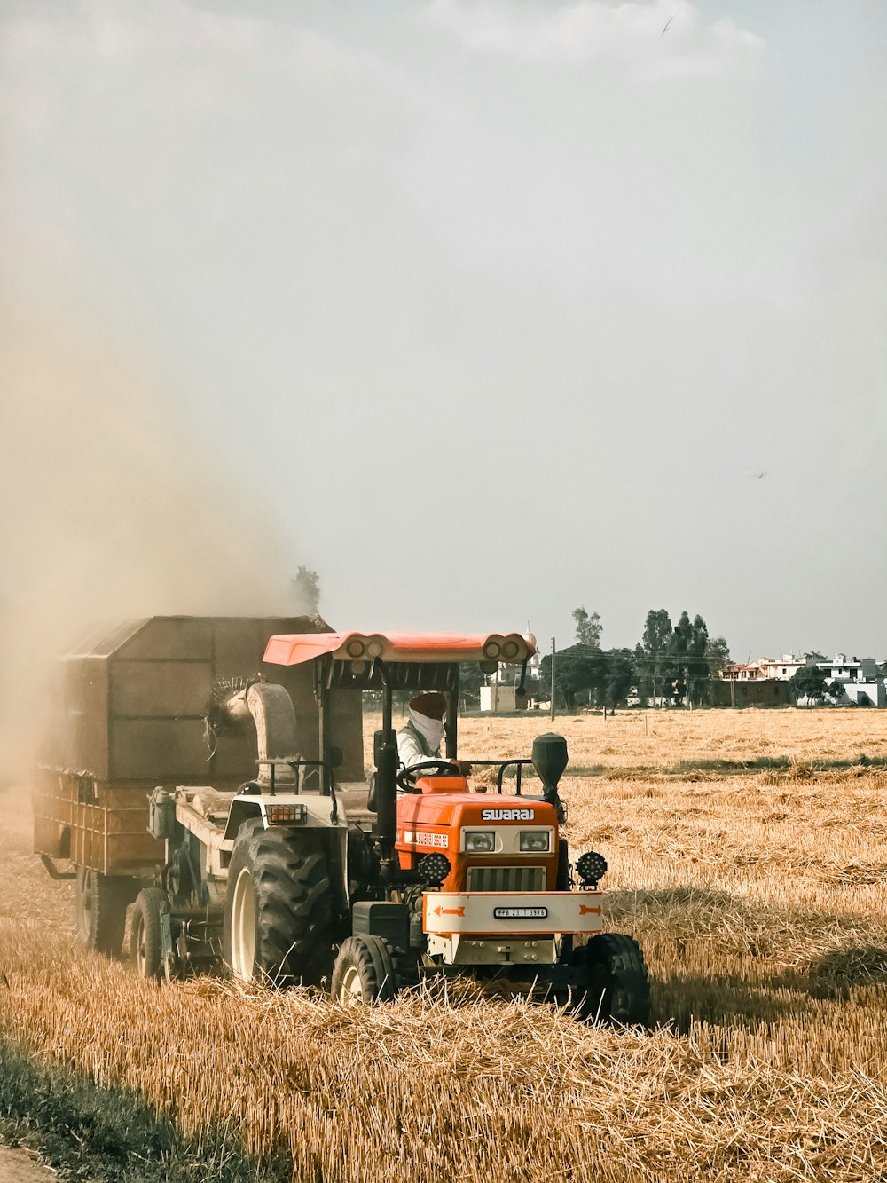 a tractor is driving through a field of wheat