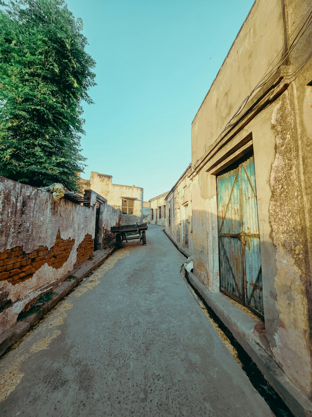 a narrow alley with a bench on the side of it