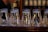 a row of glass vases sitting on top of a wooden table