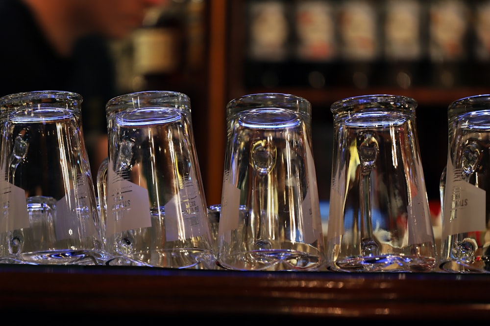 a row of glass vases sitting on top of a wooden table