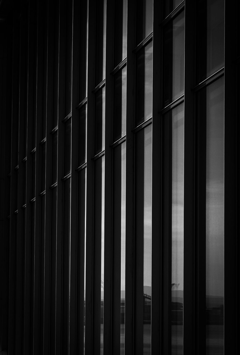 a black and white photo of a wall of windows