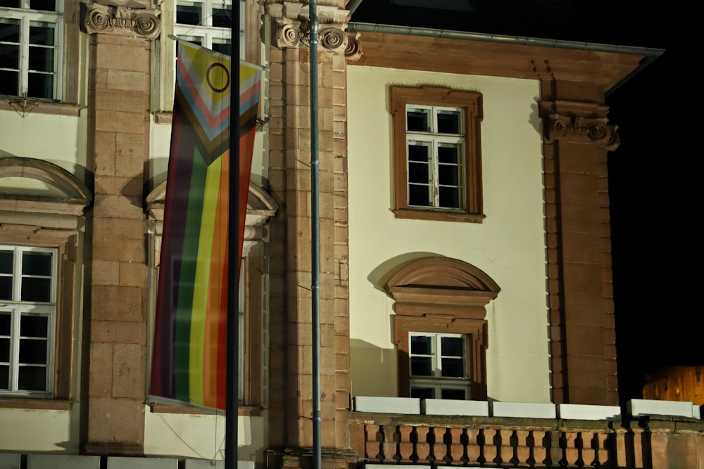 a building with a rainbow flag hanging from it's side