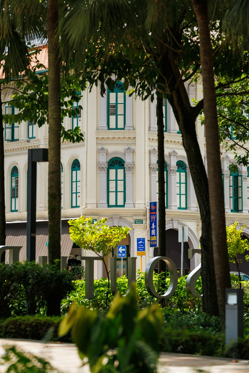 a large white building surrounded by trees and bushes